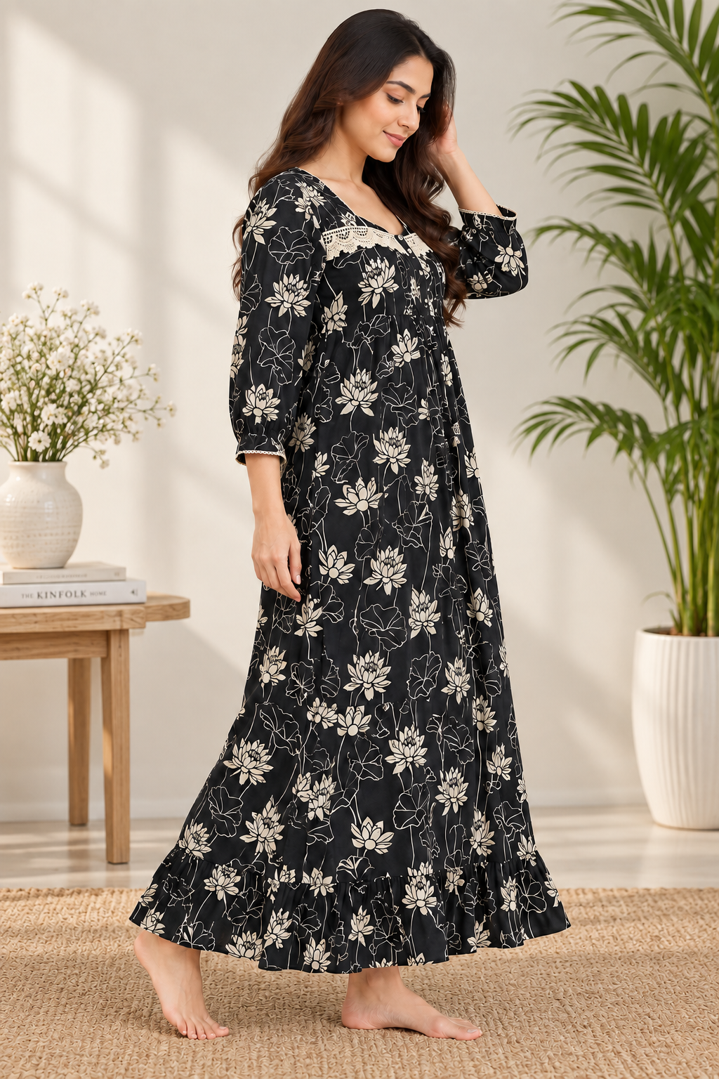 Woman wearing Sephani black floral cotton full-length nightdress with elegant lace neckline detail.